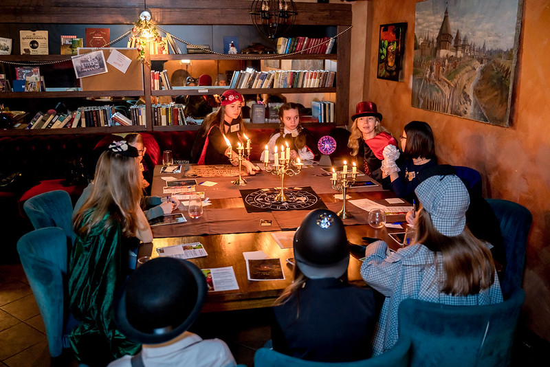 Дети разгадывают загадки в семейном квесте Хэллоуина в Yaroslavl